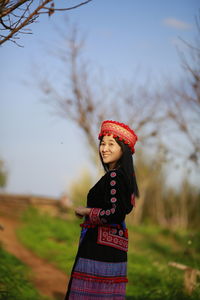 Woman looking away while standing on field