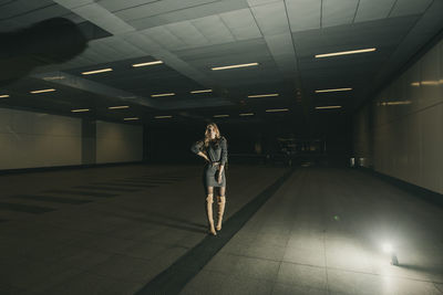 Portrait of young woman standing in subway