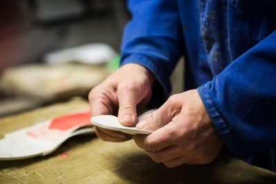 Midsection of man making footwear