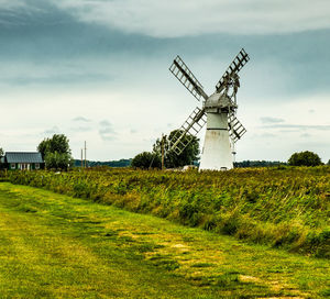 Traditional windmill on field against sky