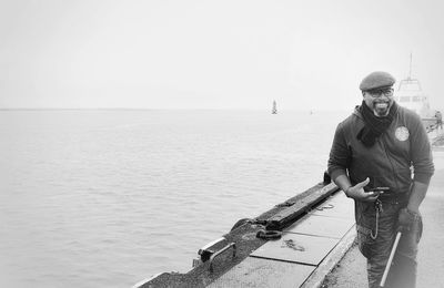 Man standing on sea against clear sky