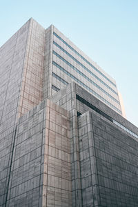 From below modern building with creative architecture under blue sky on background in dallas, texas