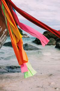 Close-up of multi colored umbrellas on beach against sky