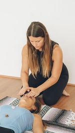 Therapist giving reiki treatment to woman