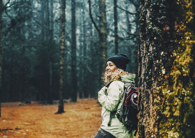 Side view of woman standing in forest