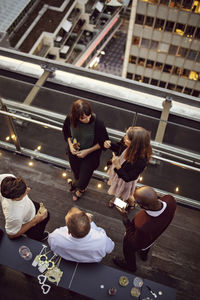 High angle view of business colleagues talking while enjoying office party after work