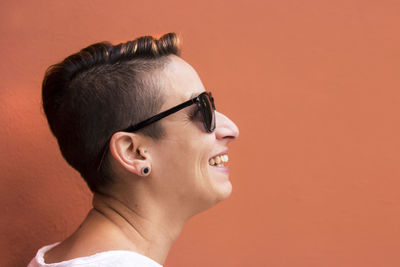 Close-up of woman against coral wall