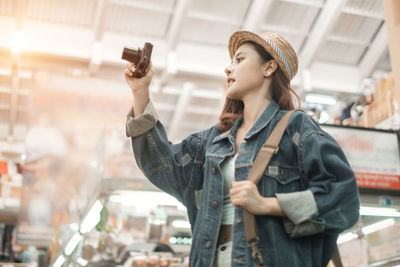 Full length of young woman photographing
