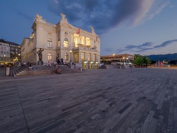 Buildings in city against cloudy sky