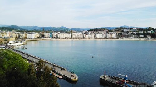 High angle view of town by sea against sky