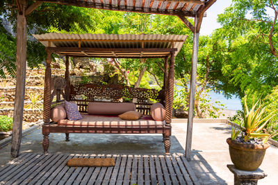 Chairs and tables in swimming pool against trees in yard