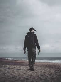 Full length of man standing on beach against sky