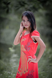 Young woman looking away while standing outdoors