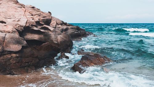 Scenic view of rocks in sea against sky