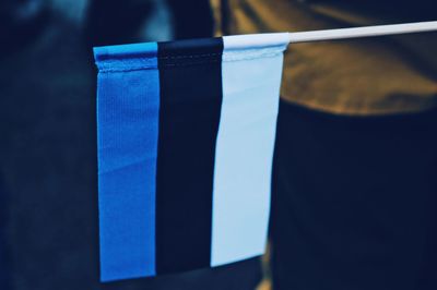 Close-up of flags against blue wall