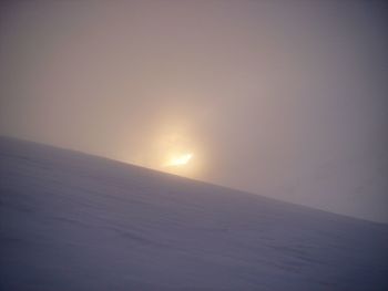 Scenic view of snowcapped landscape against clear sky during sunset