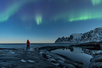 Man standing on snow against sky at night during winter