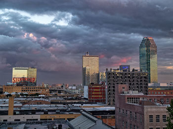 Buildings in city against cloudy sky