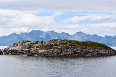 Scenic view of mountains and sea against cloudy sky