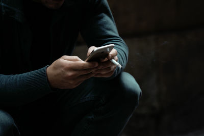 Midsection of man using mobile phone