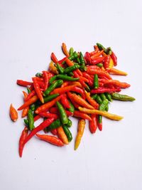 High angle view of red chili peppers on white background