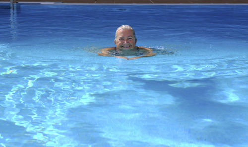 Portrait of senior woman swimming in pool