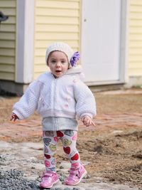 Portrait of cute girl standing on footpath