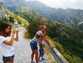 Family standing against mountain at observation point