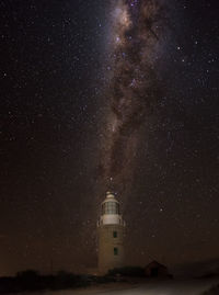 Low angle view of lighthouse against sky at night