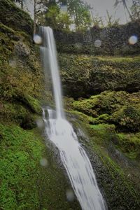 Scenic view of waterfall against sky