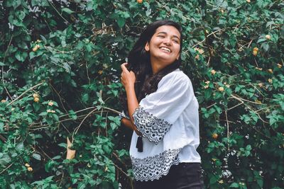 Portrait of smiling young woman standing outdoors