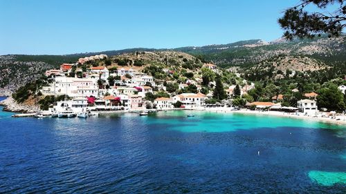 Scenic view of sea by buildings against clear sky