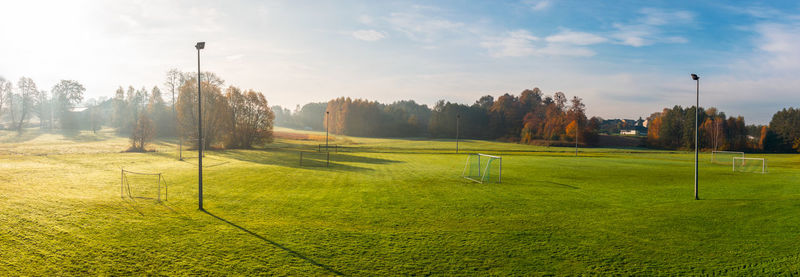 Panoramic view at small, local football pitch surrounded by trees. 