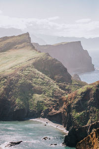 Scenic view of ocean and mountains against sky