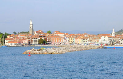 Buildings in town against clear blue sky