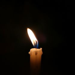 Close-up of burning candle in darkroom