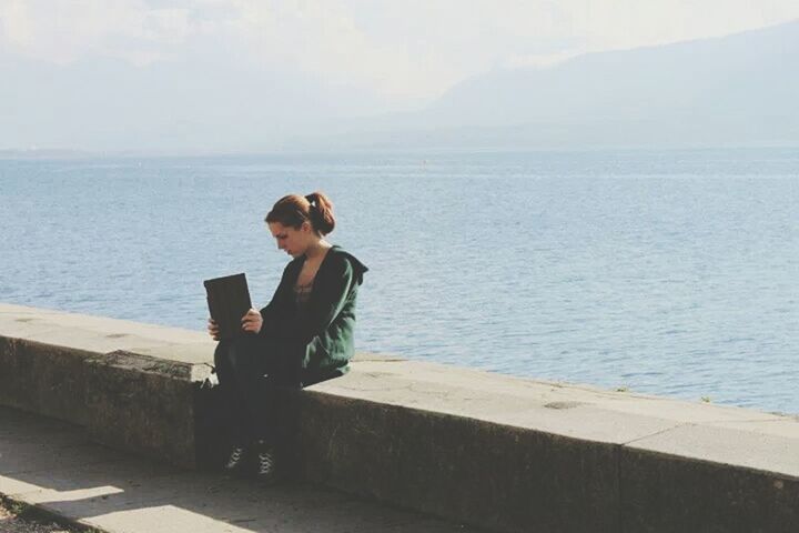 sea, water, lifestyles, horizon over water, leisure activity, sky, tranquility, tranquil scene, rear view, scenics, sitting, relaxation, beauty in nature, standing, full length, nature, casual clothing, looking at view