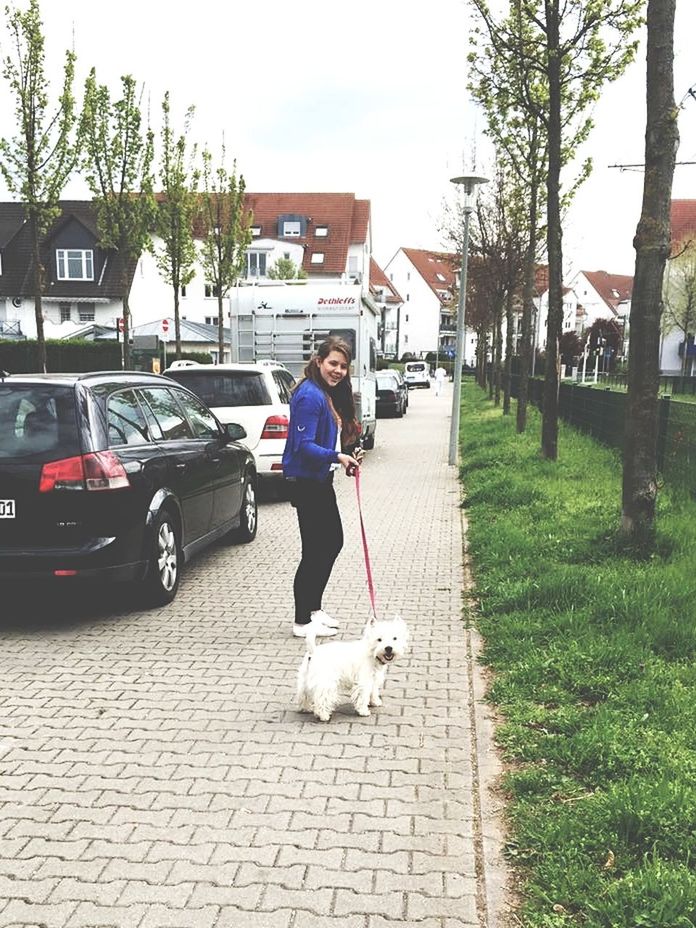 one woman only, full length, car, only women, one person, city, casual clothing, adults only, street, tree, building exterior, outdoors, one young woman only, people, built structure, adult, day, portrait, young adult, young women, architecture