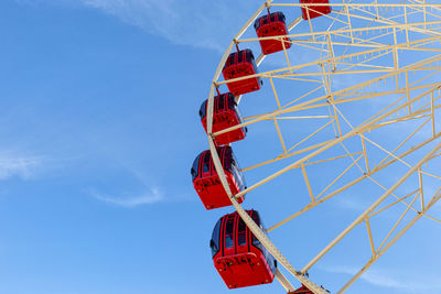 Low angle view of ferris wheel against blue sky