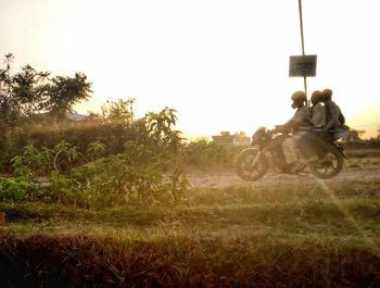 Man riding motorcycle on field against clear sky