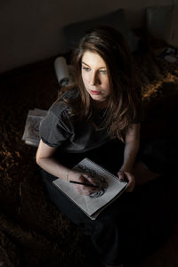 High angle view of woman sketching book