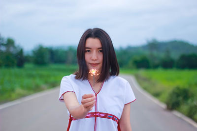 Portrait of beautiful woman standing on road
