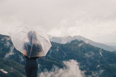 Man standing on mountain against sky