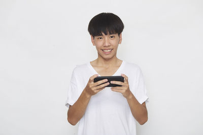 Young man using mobile phone against white background