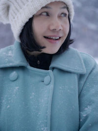 Smiling mature woman wearing warm clothing looking away during winter