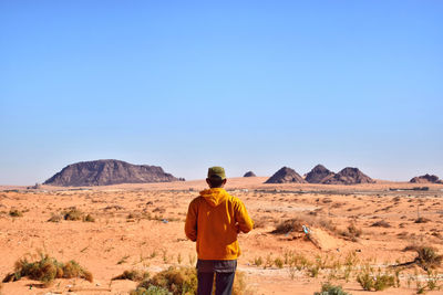 Rear view of man standing on desert