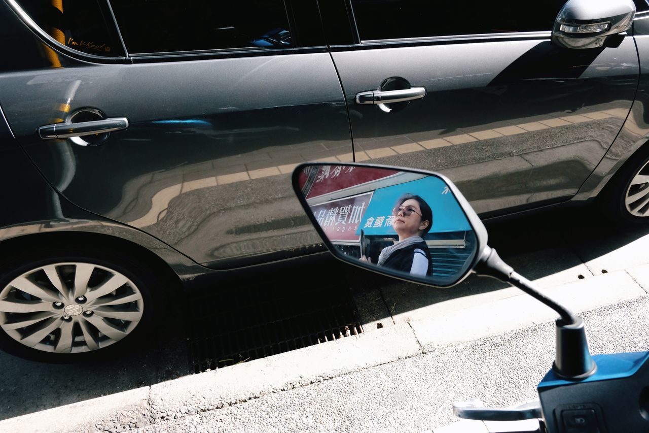 mode of transportation, transportation, car, motor vehicle, land vehicle, one person, real people, lifestyles, day, men, travel, reflection, leisure activity, young adult, adult, portrait, mid adult, side-view mirror, outdoors