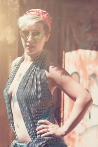 Portrait of young woman wearing sunglasses standing outdoors