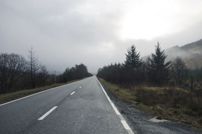 Road amidst trees against sky