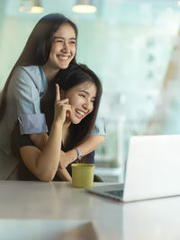 Smiling businesswomen using laptop at office